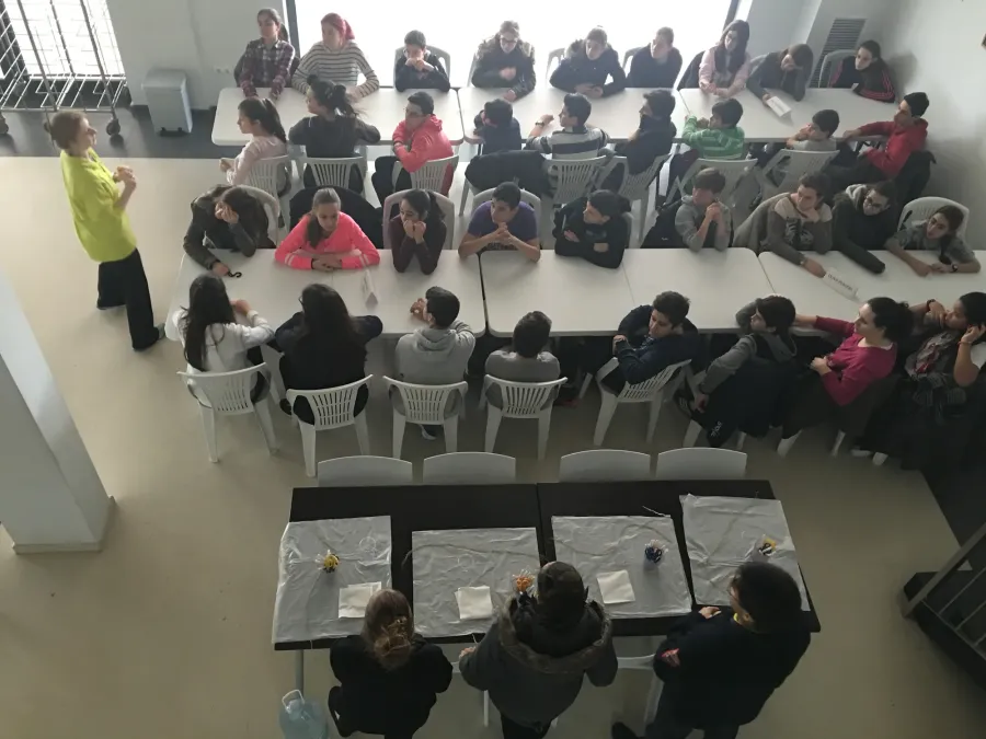 Vista cenital de alumnos trabajando en grupos en el salón