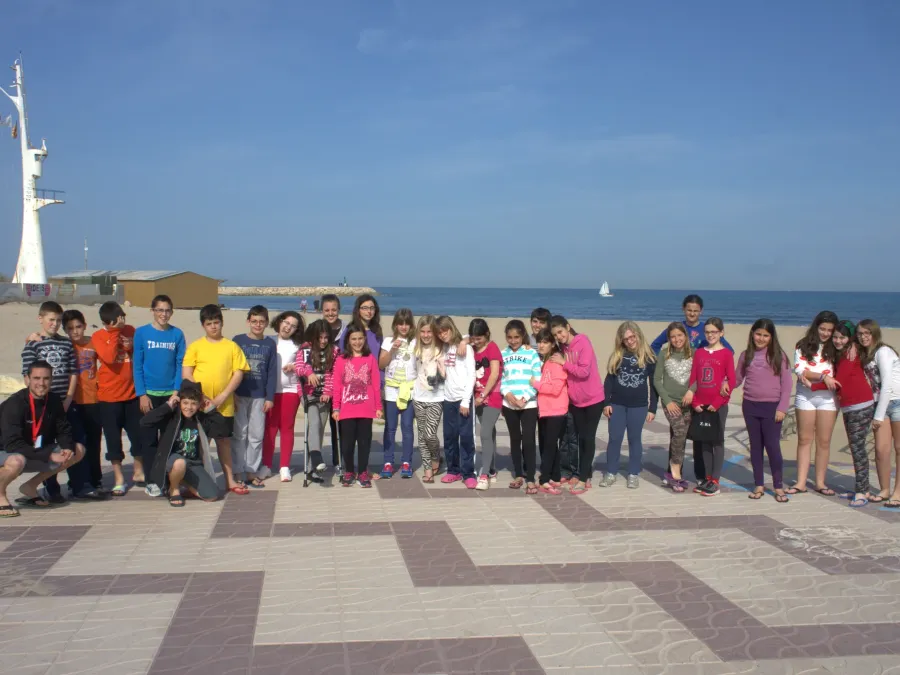 Foto de grupo de alumnos y monitores en el paseo marítimo frente a la playa