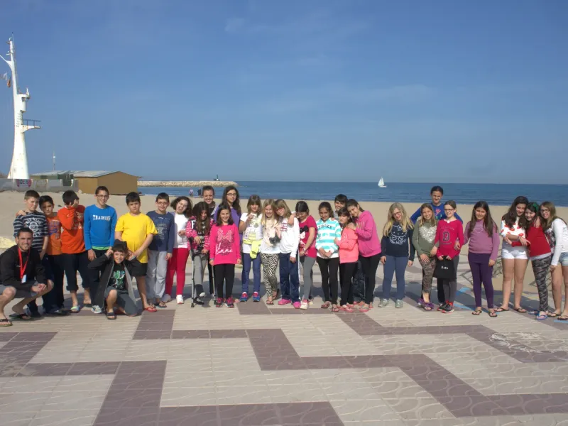 Foto de grupo de alumnos y monitores en el paseo marítimo frente a la playa