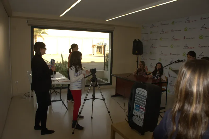 Profesora y alumnas preparan una grabación con cámara en el plató