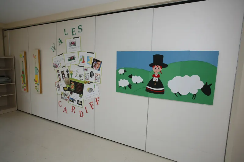 Aula temática de Gales con mural de ovejas y rincón de Cardiff