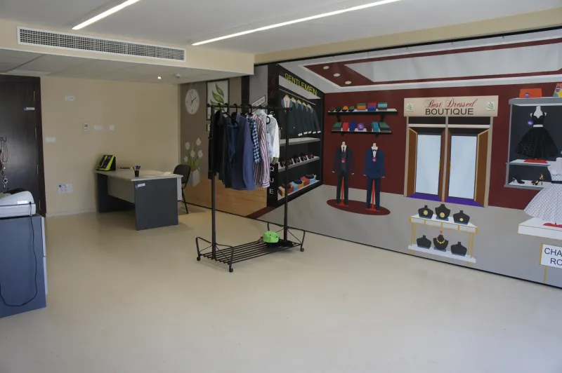 Aula ambientada como tienda de ropa con perchero y mostrador